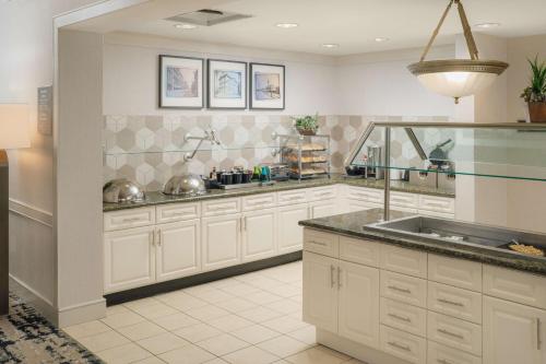 a large kitchen with white cabinets and a sink at Homewood Suites by Hilton Knoxville West at Turkey Creek in Knoxville