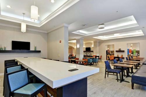 an empty waiting room with tables and chairs at Hampton Inn Palm Beach Gardens in Palm Beach Gardens