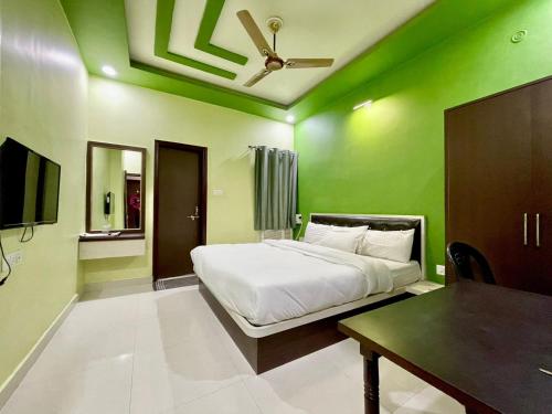 a green bedroom with a bed and a table at The White Canyon Hotel in Varanasi
