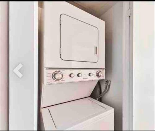 eine Mikrowelle auf einer Waschmaschine und einem Trockner in der Unterkunft Beautiful Unit in Heart of Downtown Toronto in Toronto