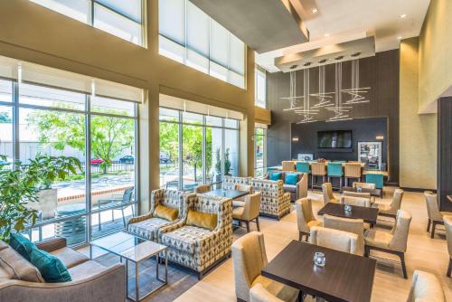 a restaurant with couches and tables and windows at Hampton Inn & Suites Tallahassee Capitol-University in Tallahassee
