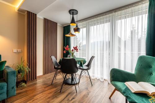 a living room with a table and chairs at Widokowy Domek Jaś i Małgosia in Kościelisko