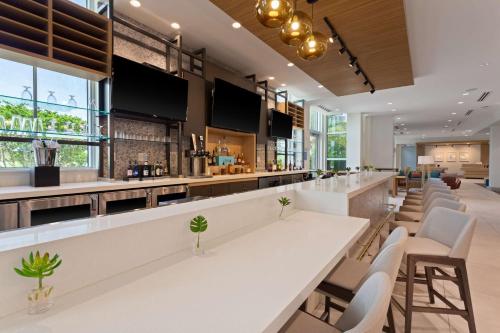 un bar in un ristorante con tavoli e sedie bianchi di Hilton Garden Inn Homestead a Homestead