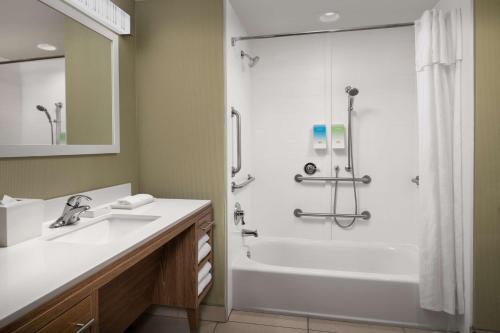 a bathroom with a shower and a sink and a tub at Home2 Suites By Hilton Summerville in Summerville