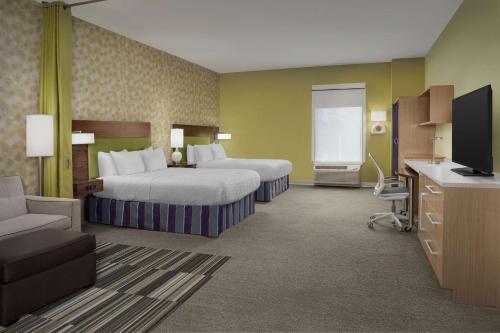 a hotel room with two beds and a flat screen tv at Home2 Suites By Hilton Summerville in Summerville