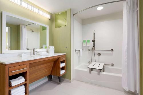 y baño con lavabo, bañera y ducha. en Home2 Suites by Hilton Champaign/Urbana en Champaign