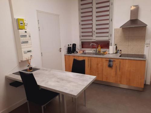 cocina con mesa con sillas y fregadero en Grand studio au calme - Dijon centre, en Dijon