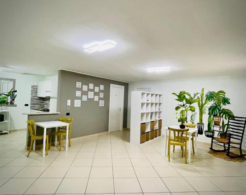 a large room with a table and chairs and a room with plants at MaNà Rooms and Apartment in Telese