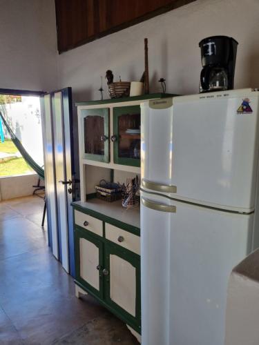 uma cozinha com um frigorífico branco e um armário verde em CASINHA AZUL/PIRINOPOLIS em Pirenópolis