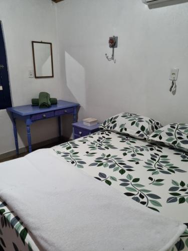 um quarto com uma cama e uma mesa azul em CASINHA AZUL/PIRINOPOLIS em Pirenópolis