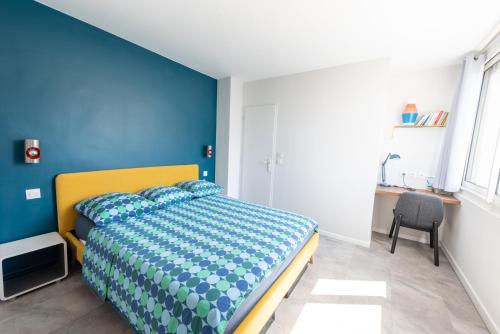a bedroom with a bed with a blue wall at Happy 70's - Family Place in Villeurbanne