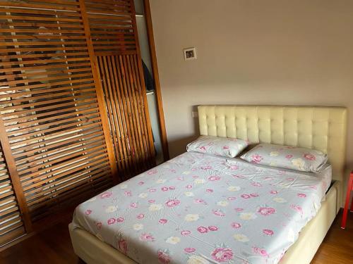 - une chambre avec un lit orné de fleurs roses dans l'établissement Appartamento incantevole a due passi dal borgo, à Montesilvano