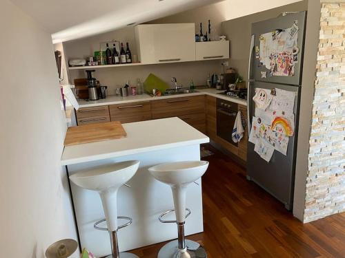 La cuisine est équipée d'un comptoir blanc et d'un réfrigérateur. dans l'établissement Appartamento incantevole a due passi dal borgo, à Montesilvano