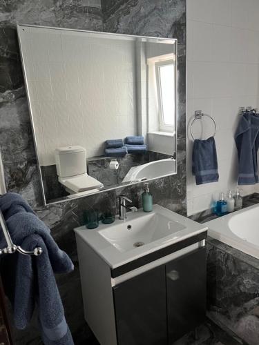 a bathroom with a sink and a large mirror at palazzo PADINI alla costa in Neoi Epivates