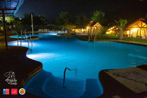 a large pool with blue water at night at Posada del Jinete in San José de Maipo