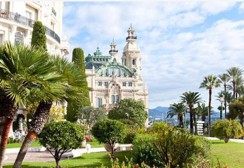 a building with a palm tree in front of it at Appartement neuf, Monaco avec vue mer in Beausoleil