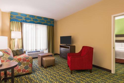 a hotel room with a couch and a tv at Homewood Suites by Hilton Little Rock Downtown in Little Rock