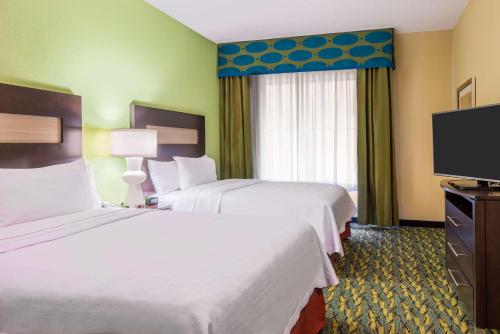 a hotel room with two beds and a flat screen tv at Homewood Suites by Hilton Little Rock Downtown in Little Rock