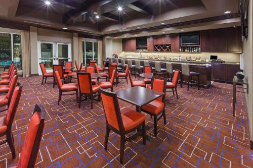 a restaurant with tables and chairs and a bar at Hilton Garden Inn Midland in Midland
