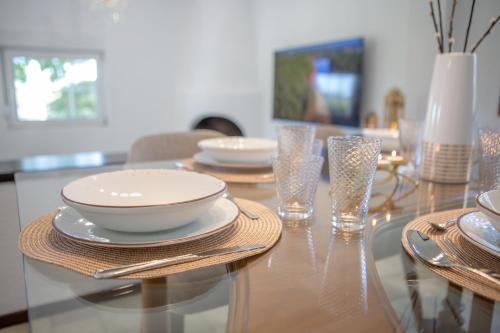 a dining room table with plates and glasses on it at Villa Komorebi in Ierápetra