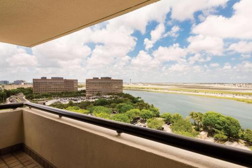 a balcony with a view of the ocean and buildings at Hilton Miami Airport Blue Lagoon in Miami