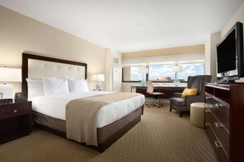 a hotel room with a large bed and a desk at Hilton Miami Airport Blue Lagoon in Miami