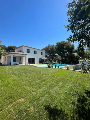 une grande cour avec une maison et une piscine dans l'établissement Villa dans les hauteurs de Marseille, à Marseille