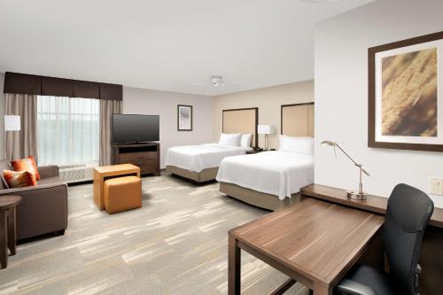 堪薩斯城的住宿－Homewood Suites By Hilton Kansas City Speedway，酒店客房设有两张床和一台平面电视。