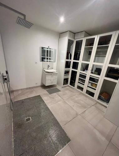 La salle de bains est pourvue d'un lavabo et de placards blancs. dans l'établissement Villa dans les hauteurs de Marseille, à Marseille