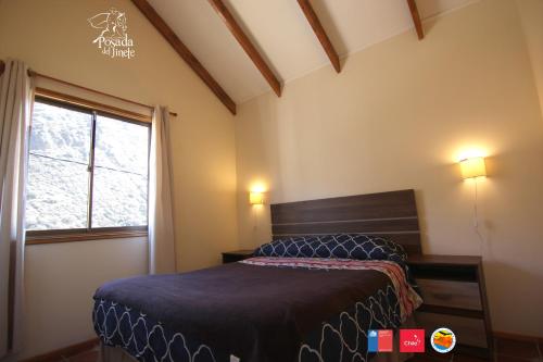 a bedroom with a bed and a window at Posada del Jinete in San José de Maipo