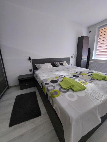 Un dormitorio con una cama grande con servilletas verdes. en Апартамент Слави en Blagoevgrad