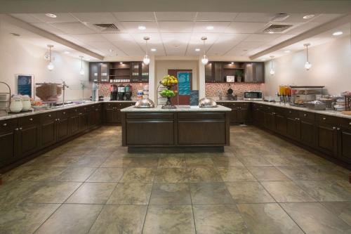 a large kitchen with brown cabinets and a large island at Homewood Suites by Hilton Phoenix-Avondale in Avondale