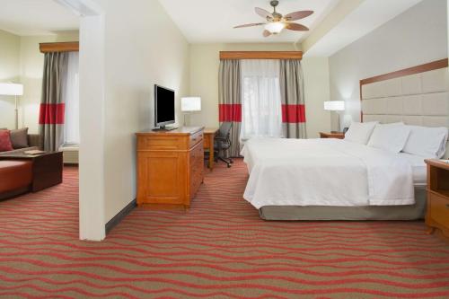 ein Hotelzimmer mit einem Bett und einem TV in der Unterkunft Homewood Suites by Hilton Phoenix-Avondale in Avondale