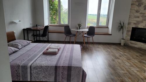 a living room with a bed and a table and chairs at Апартаменти біля Фортеці in Kamianets-Podilskyi