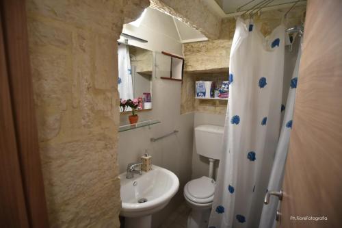 ein Badezimmer mit einem weißen WC und einem Waschbecken in der Unterkunft Home Ginny in Terlizzi
