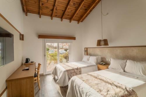 ein Hotelzimmer mit 2 Betten und einem Fenster in der Unterkunft La Campiña Club Hotel & Spa in Santa Rosa