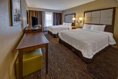 a hotel room with two beds and a television at Hampton Inn Dunn in Dunn