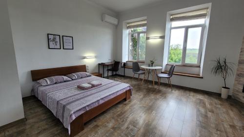 um quarto com uma cama, uma mesa e cadeiras em Апартаменти біля Фортеці em Kamianets-Podilskyi