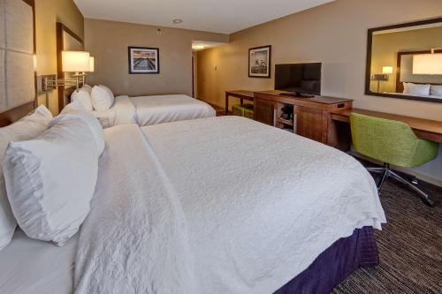 a hotel room with two beds and a desk at Hampton Inn Dunn in Dunn