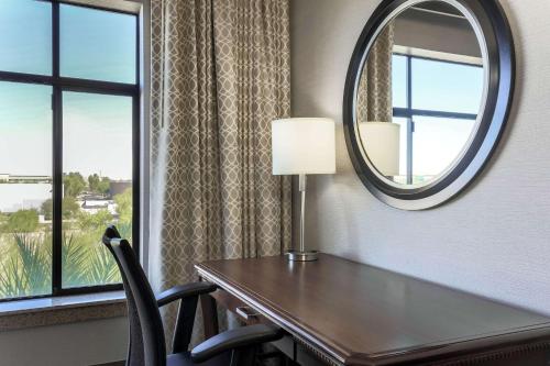 a room with a table and a mirror and a window at Hilton Phoenix Chandler in Chandler
