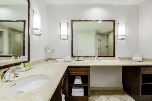 a bathroom with two sinks and a large mirror at Hilton Phoenix Chandler in Chandler