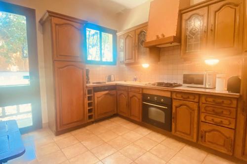 une cuisine avec des armoires en bois et un four à plaques de cuisson dans l'établissement Rare pearl with garden near Arcachon, à La Teste-de-Buch