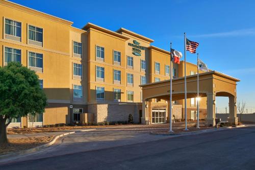 a hotel with two american flags in front of it at Homewood Suites Odessa in Odessa