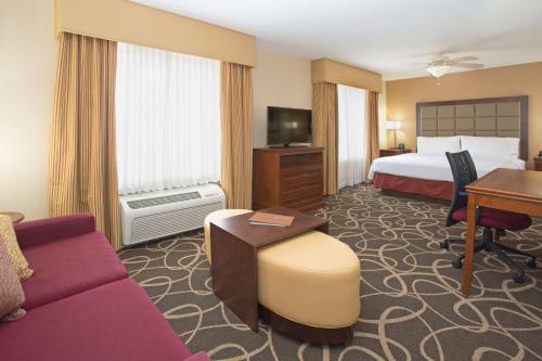 尤馬的住宿－優馬希爾頓惠庭套房酒店，配有一张床和一张书桌的酒店客房