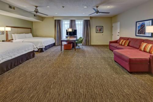 a hotel room with two beds and a couch at Hampton Inn Savannah-I-95-North in Port Wentworth