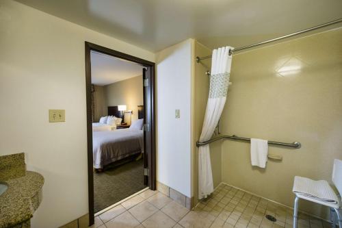 a hotel room with a bathroom with a bed and a shower at Hampton Inn & Suites Toledo-Perrysburg in Rossford