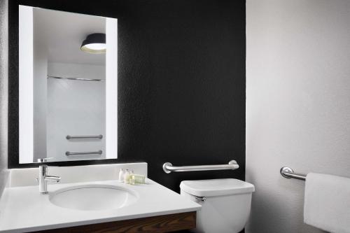 a bathroom with a sink and a toilet and a mirror at Killington Mountain Lodge, Tapestry Collection by Hilton in Killington