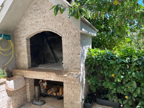 a stone pizza oven in front of a hedge at Blue pearl apartment in Imotski