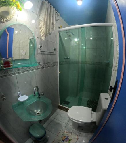 a bathroom with a shower and a sink and a toilet at Pousada Pedacinho de Céu in Abraão
