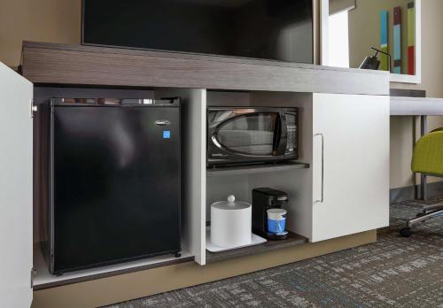 a cabinet with a tv and a microwave on it at Hampton Inn & Suites Chicago/Waukegan in Waukegan